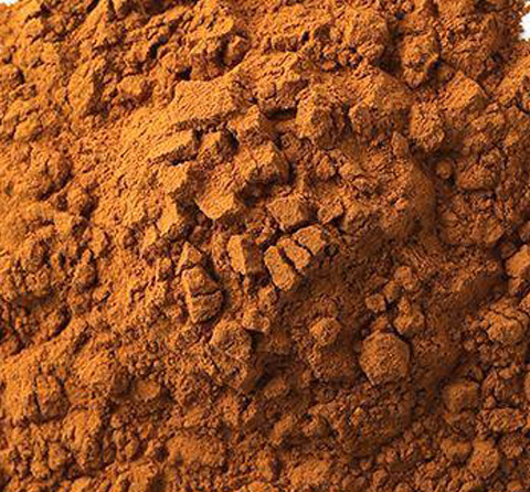 Close-up of red chile flakes and powder on an orange-brown surface