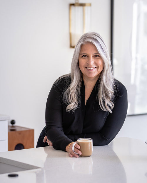 Portrait of food blogger Heather Scholten from Farmgirl Gourmet smiling in casual attire against rustic kitchen background