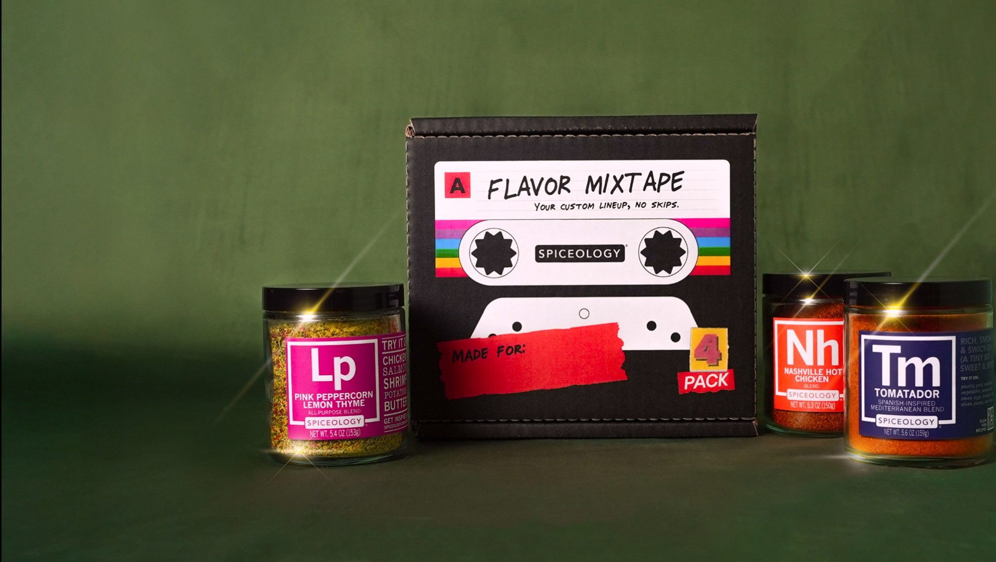 Spiceology Flavor Mixtape 4-pack gift box styled like a cassette tape with Pink Peppercorn Lemon Thyme, Nashville Hot Chicken, and Tomatador spice blend jars displayed on a green background