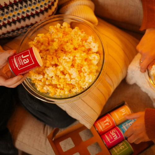 Gourmet popcorn assortment in decorative gift tins displayed at specialty shop counter