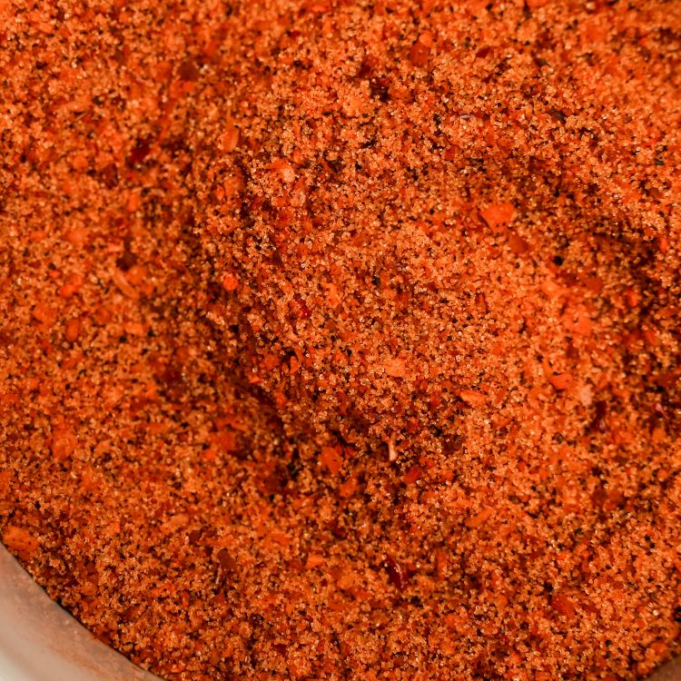 Close-up of a red spice blend in a container