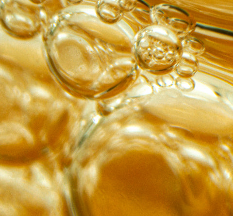 Close-up of golden liquid droplets with a blurred background